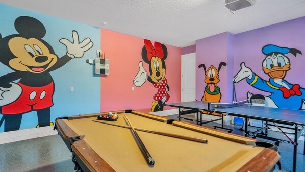 Unleash fun in this vibrant game room featuring iconic cartoon murals, a pool table, and ping pong for endless entertainment!