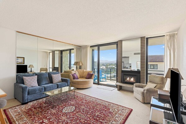 Relax by the fireplace with stunning ocean glimpses! Cozy living space for memorable moments. Book your escape now!