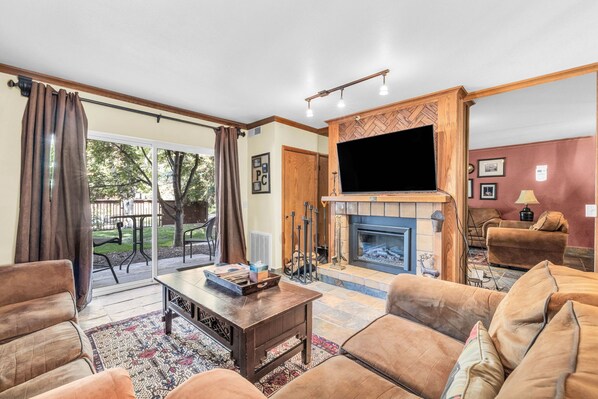Living Room: 2 couches, 55” TV, wood burning fireplace, access to patio