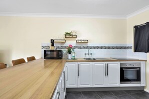 Fully equipped kitchen with a stove, oven, fridge/freezer and other staples for your convenience.