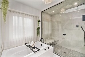 The ensuite luxury bathroom features a soothing soaker tub, a convenient bidet, and a rejuvenating steam shower, offering a spa-like experience in the comfort of your own space.