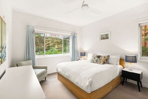 Bid goodnight to nature from the primary bedroom featuring a plush king-sized bed. 
