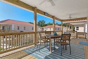 A large porch with an outdoor dining set overlooking TradeWinds