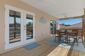 A large porch with an outdoor dining set overlooking TradeWinds