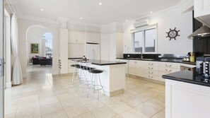 Well appointed kitchen with island bench and stainless steel appliances.