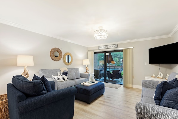 Spacious living room with 2 sofas (one is a queen sleeper) and a plush chair

