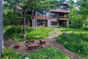 The fire pit and upper lawn on the back side of the Lodge House, facing west over Roy Lake.