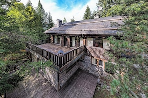 Experience the charm of this rustic cabin nestled in the woods. The spacious deck offers a perfect spot for outdoor dining and relaxation, surrounded by serene beauty of the forest.