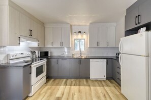 Modern grey and white kitchen with sleek finishes and a clean design — fully equipped for effortless cooking and dining.