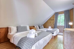 Inviting wood and white bedroom with two comfortable beds—perfect for friends or family traveling together.