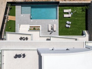 Admire the villa and its picturesque surroundings from a stunning aerial view.