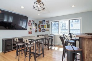 Upstairs loft with bar height table / chairs and a dry bar with stools. Check out that TV!