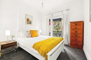 The primary bedroom is set upstairs with a plush queen-sized bed and opens to a quaint balcony.
