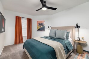 Bedroom with plush beddings, ceiling fan, TV w/ Netflix , and curtains