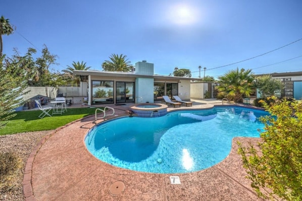 Outdoor Oasis: Relax by the stunning pool and soak in the sun surrounded by lush greenery!