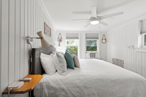The bedroom features windows that invite natural light and offer backyard views.