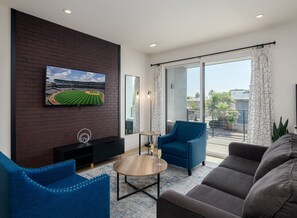 1st Floor: Modern open living space that features a smart TV and entrance to a private patio.
