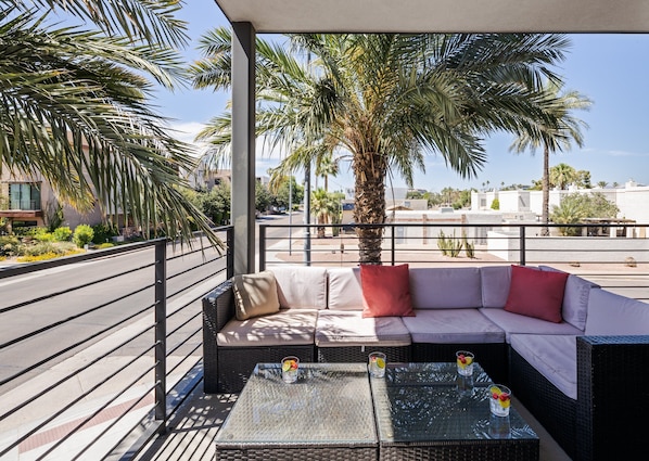 Unit 2 (1st Floor): Private balcony off the living room offering outdoor furnishings for lounging.