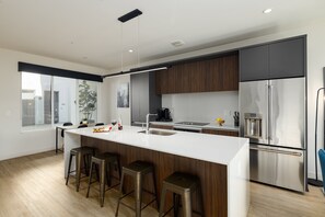 Unit 1 (1st Floor): Fully equipped modern kitchen completely stocked with all culinary essentials and includes high-end Cafe stainless steel appliances. Dining table offers a space for four.