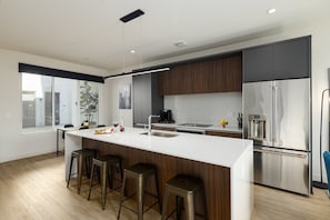 Unit 1 (1st Floor): Fully equipped modern kitchen completely stocked with all culinary essentials and includes high-end Cafe stainless steel appliances. Dining table offers a space for four.