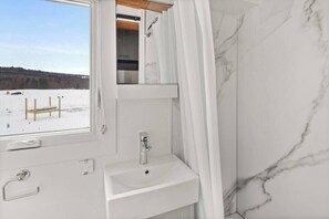 Bathroom with functioning plumbing, toilet, sink and shower.