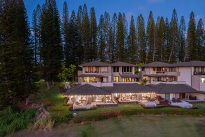 Enjoy the warm evening ambiance of Kapalua Villas, surrounded by towering pines and glowing interiors for a memorable stay.