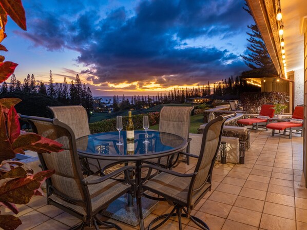 Unwind with a glass of wine and sunset dining on the villa's private patio, featuring panoramic views of Kapalua's lush surroundings.