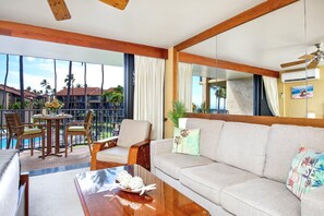 Relax beneath cooling fans in a bright, mirror-kissed living room where hand-carved chairs add a touch of aloha flair     PKE-304