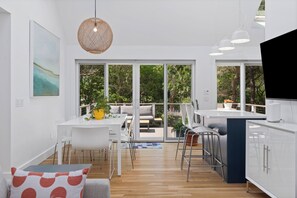 View of dining area and kitchen bar out to deck
