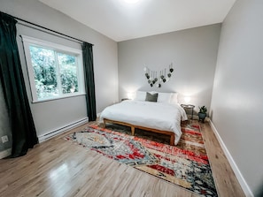 Side tables with lamps and charging pads and blackout curtains