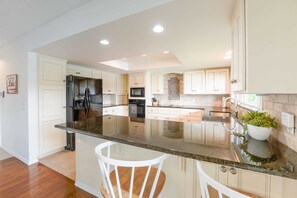 Prepare your favorite meals in this well-equipped kitchen featuring modern amenities and a touch of lakeside charm.