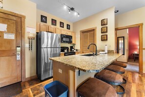 Full kitchen with breakfast bar, new appliances, and coffee maker.
