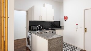 A compact yet functional kitchenette equipped with essential appliances like a mini-fridge, microwave and coffee maker. It even counts with a washing machine! #modern #practical