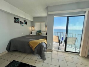 Welcome the day with a sunrise awakening in our oceanfront studio suite, where a bed near the balcony offers a front-row seat to the morning sun painting the sky over the ocean.