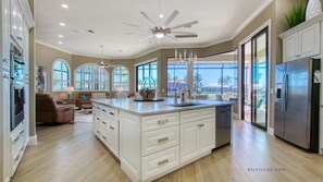 Gourmet kitchen with top-tier appliances, cookware, and elegant dishware for seamless cooking.