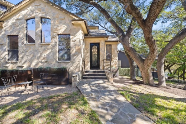 Exterior of home with mature oak trees for relaxing in the shade.