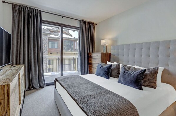 Spacious bedroom with a plush bed and a private balcony, perfect for enjoying your morning coffee.