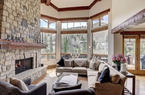 Cozy living room with a stone fireplace and panoramic views.