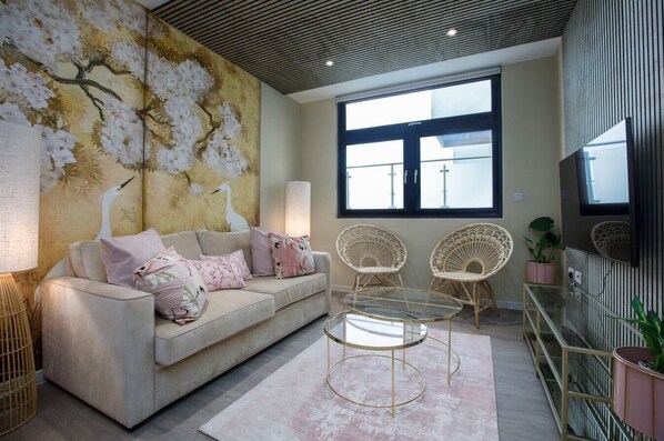 Living room with a sofa, armchairs, dining table, and Smart TV