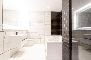 Bathroom with a jacuzzi and a separate shower.