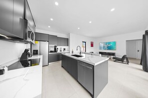 Modern kitchen equipped with stainless steel appliances, including a refrigerator, stove, and microwave, perfect for cooking up a storm during your stay!