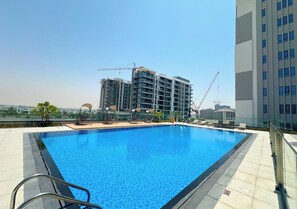 Poolside area offering views of the cityscape and lush greenery.