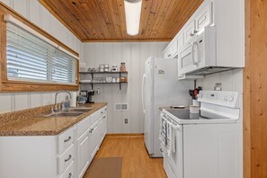 full kitchen with frig, oven, stove top, microwave, keurig, drip coffee pot