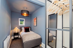 Cozy single bedroom down a couple of stairs from the hallway