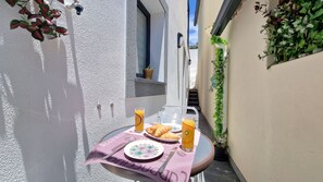 Delightful patio with a small table—perfect for enjoying breakfast or dinner in a charming, tranquil setting. Ideal for a cozy, al fresco experience.