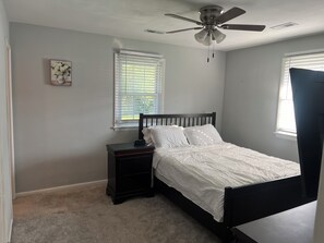 Master bedroom with bathroom, smart tv and a queen size bed. 
