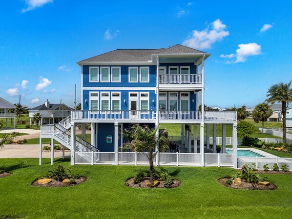 Stunning blue façade with spacious decks and lush tropical landscaping awaits