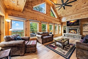 Main level living room featuring large gas fireplace & 65" TV.