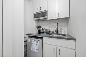 Efficient kitchenette featuring a mini fridge, stovetop, and a coffee maker