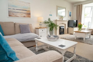 Sitting room with corner sofa, TV and electric fire